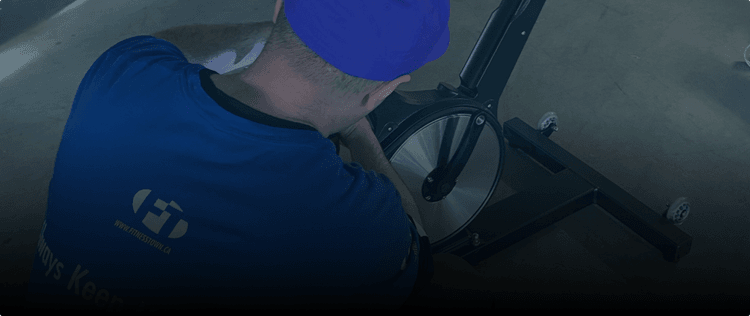 Fitness Town associate repairing Keiser Bike